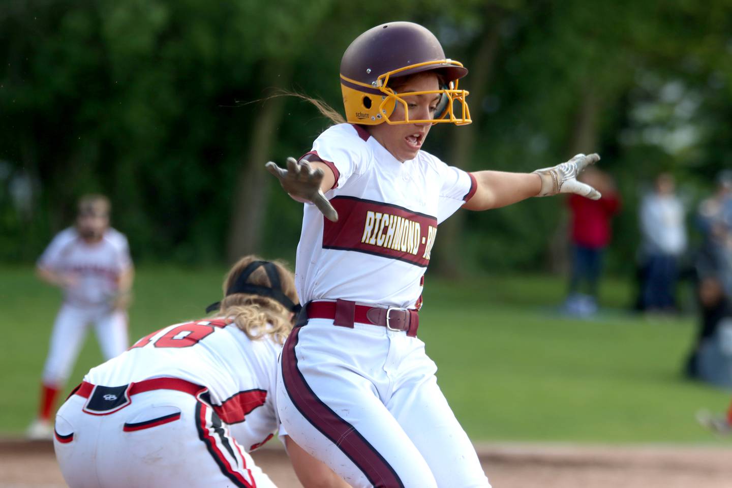 Richmond-Burton’s Adriana Portera signals safe as she glides across first base with a bunt single against Stillman Valley in softball sectional title game action in Richmond Friday evening.