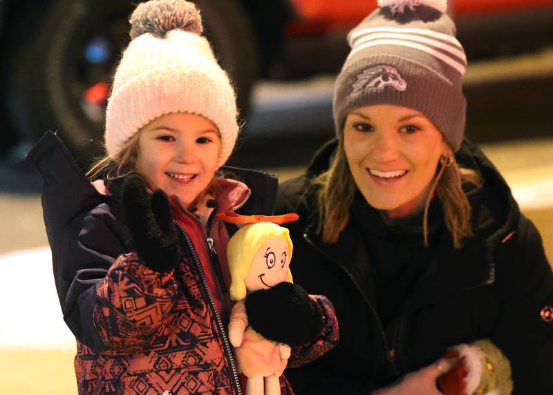 Traci Saboch and her daughter Adalyn, 3, from Sycamore, wave to Santa and Mrs. Claus as the make their way down State Street Friday, Dec. 6, 2024, during the Sycamore Chamber of Commerce’s Walk With Santa in downtown Sycamore.