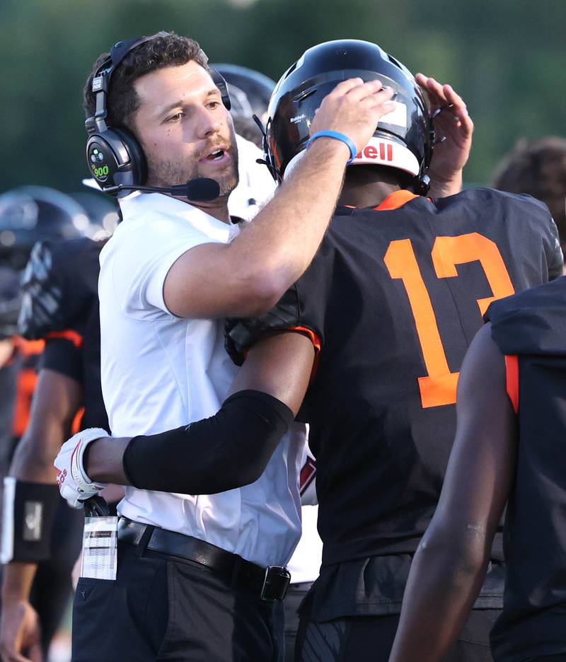 DeKalb head coach Derek Schneeman congratulates DeKalb’s Davon Grant after he scored the games first touchdown against Plainfield South Friday, Sept. 1, 2023, at DeKalb High School.