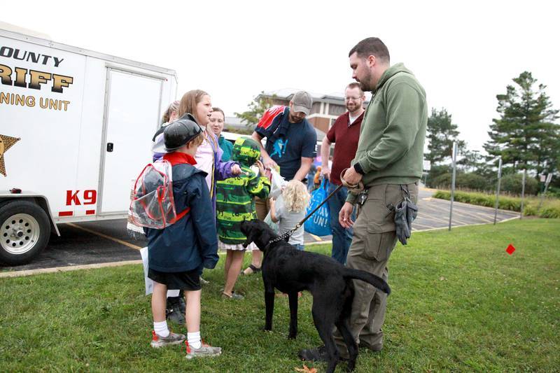 Kane County Sheriff Deputy Matt Schultz and his 8-month-old K-9 in training, Remi, greet children duirng the Kane County Sheriff’s National Night Out in St. Charles on Tuesday, Aug. 6, 2024.