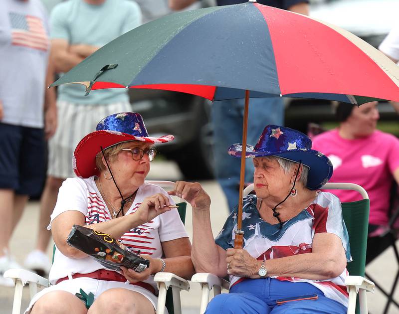 MeLisa Feeley (left) and Cleo Bankord, both from Cherry Valley, share a snack as they wait for the start of the festivities Friday, July 4, 2025, during the Fourth of July parade in downtown Kirkland.