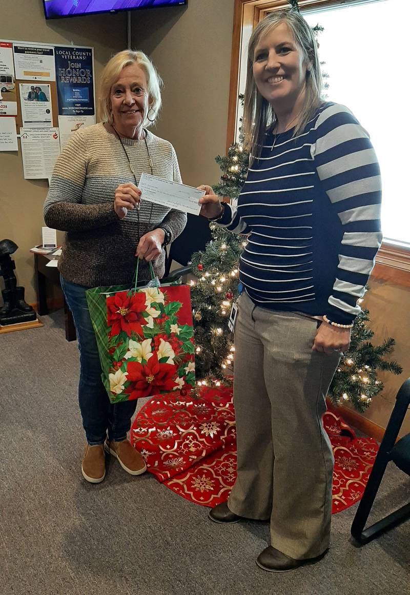Ottawa Moose Lodge 960 Treasurer  Teresa Sigler (left) presents a donation and a Christmas gift for Veteran from the Giving Tree to Lisa Olson, assistant superintendent of La Salle County Veterans Assistance Commission.