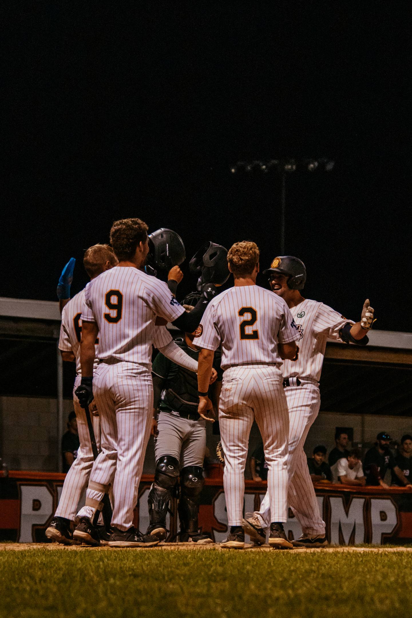 Jack Johnston (right) is welcomed at home plate by teammates after hitting a grand slam during the Illinois Valley Pistol Shrimp's 11-10, 10-inning victory over the Danville Dans on Thursday, July 18, 2024 at Schweickert Stadium in Peru.