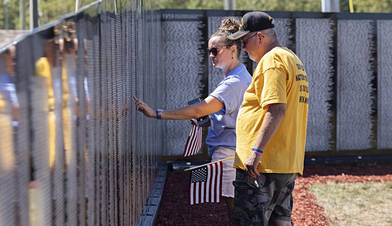 Renee Bierer helps dad Art Oldham of Tampico locate one of three names located on the Vietnam Traveling Memorial Wall Thursday, August 31, 2023 in Rock Falls.