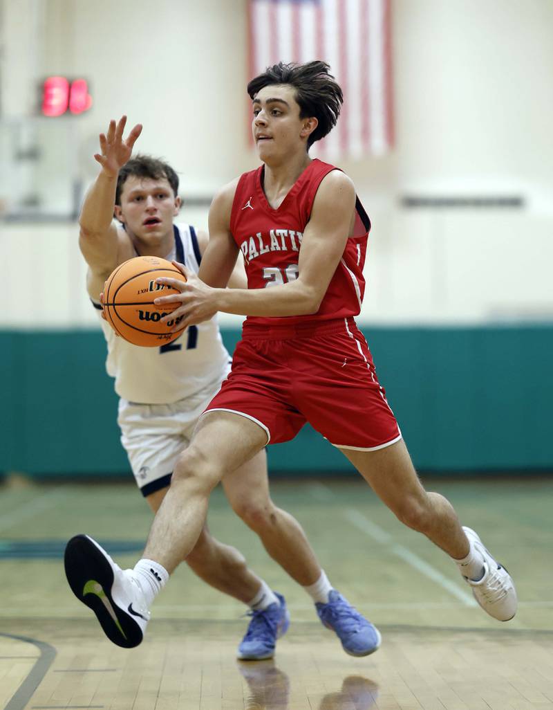 Downers Grove South’s Daniel Laurich (21) tries to knock the ball loose as Palatine’s Andy Iliopoulos (20) drives to the lane during the Jack Tosh Holiday Tournament Thursday, Dec. 26, 2024 at York High School in Elmhurst.