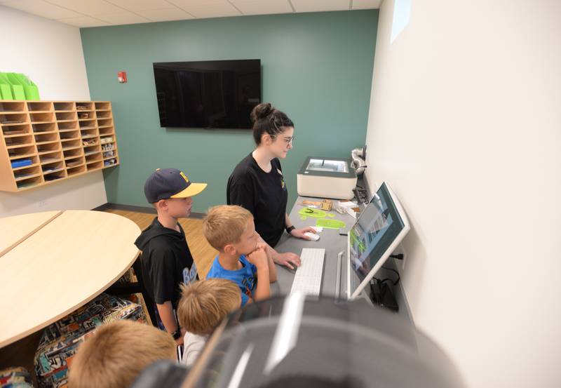 Librarian Catie Synowicz helps children including Cole Bocian of Lagrange Park and Jacob Janssen of Lagrange Highlands make personalized key chains during the La Grange Park Library Grand Reopening Saturday Aug. 3, 2024.
