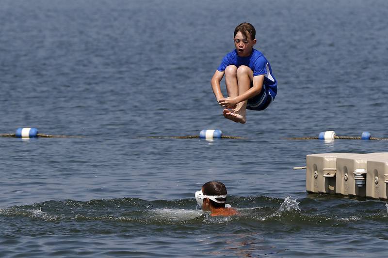 A boy does a cannon ball while swimming at Crystal Lake's Main Beach on Friday, June 21, 2024.