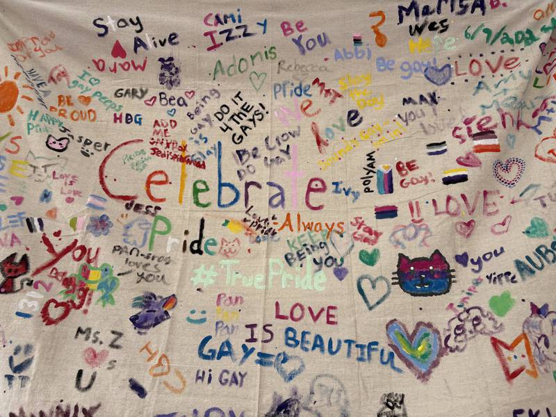 A canvas with drawings hangs inside the True Value booth during Woodstock PrideFest June 15, 2025.