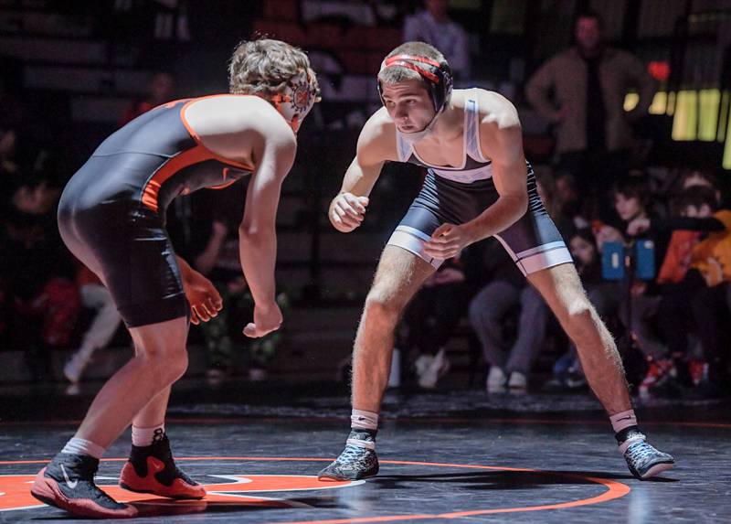 St. Charles East’s Ben Davino and Marian Central’s Vance Williams wrestle at 138 pounds during a match in St. Charles on Wednesday, December 20, 2023.