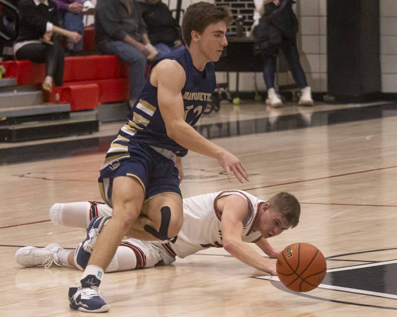 Marquette's Denver Trainor and Jon Moore of Woodland High School both try to gain possession of a loose ball during the varsity basketball game at Woodland on January 30, 2024.
