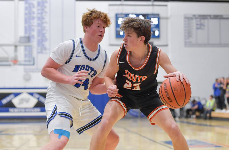 St. Charles North's Jake Furtney (34) guards Wheaton Warrenville South Max O'Connell (23) during a game on Friday, December 2, 2022.
