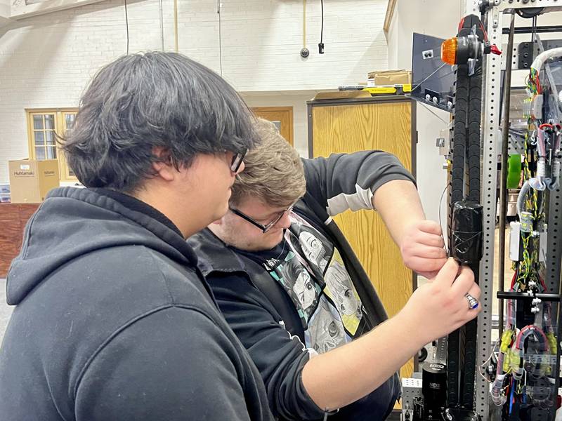 Sterling High School robotics team members Manuel Mejia and Brevin Folsom make adjustments to the team's robot Wednesday, March 5, 2025, at Sterling High School.