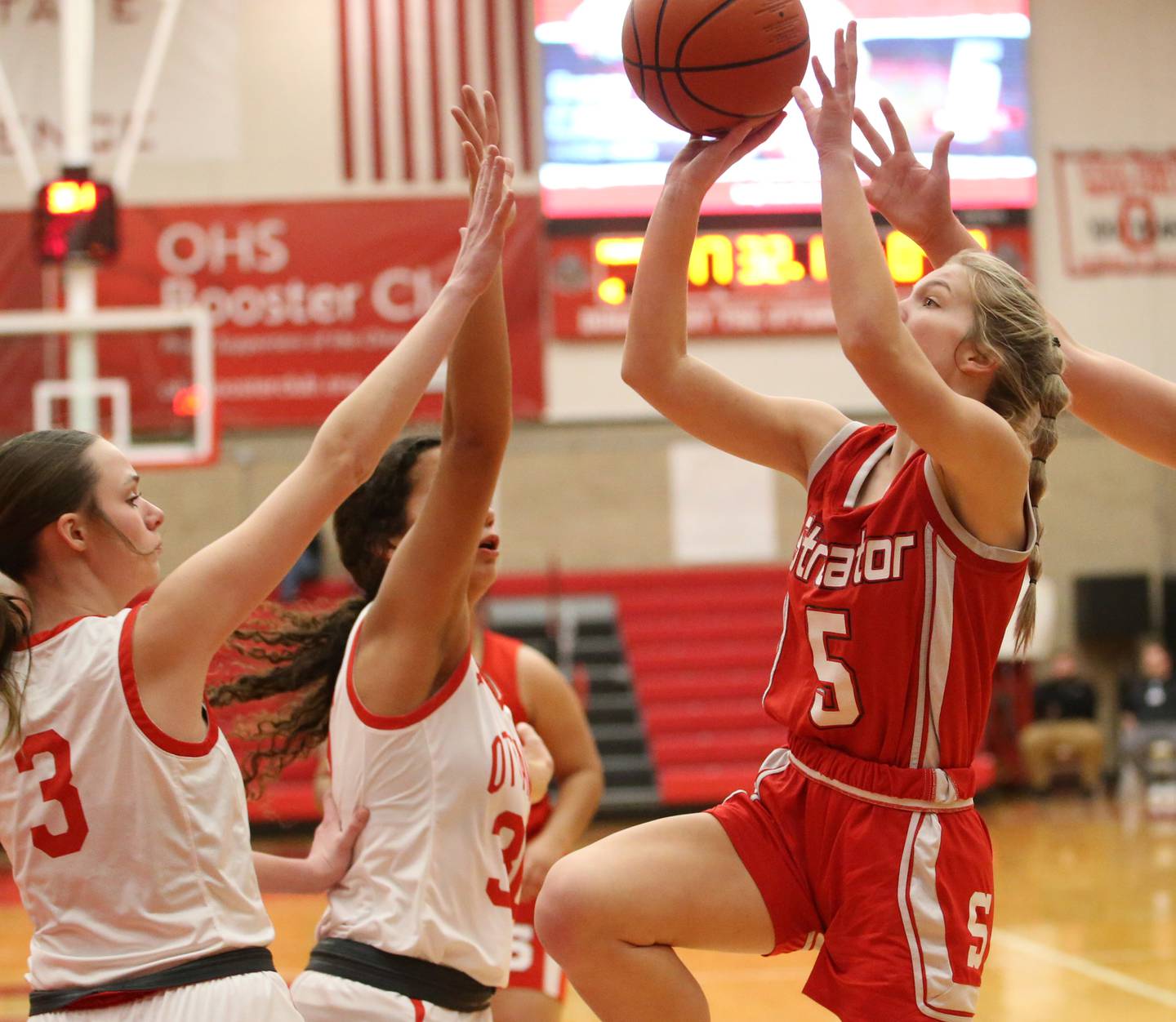 Streator's Joey Puetz runs into the lane to score a basket over Ottawa's Morgan Stone and Michaela Froisland on Wednesday, Feb. 1, 2023 at Ottawa High School.