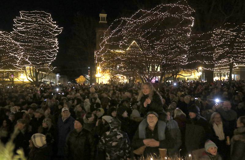 Thousands of people gather under the lights during Lighting of the Square Friday, Nov. 24, 2023, in Woodstock. The annual holiday season event featured brass music, caroling, free doughnuts and cider, food trucks, festive selfie stations and shopping.
