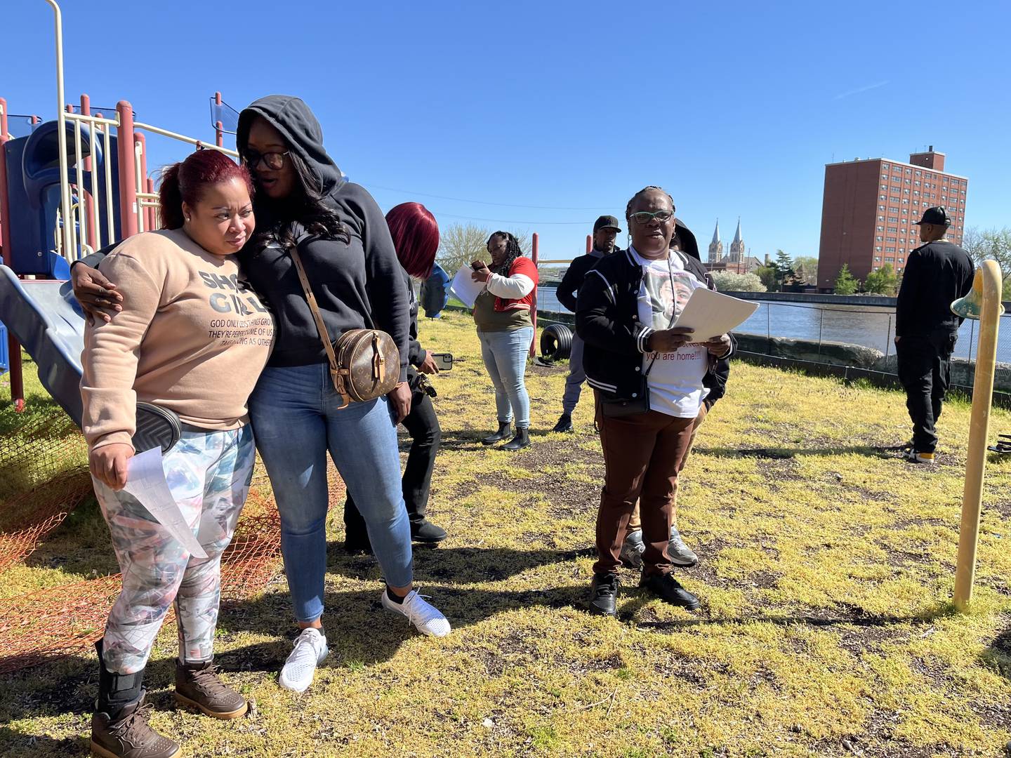 Jewell Robinson (right) passes out fliers to family, friends and others on Friday, April 19, in Joliet, for the search of her missing son, Robert Long, 37.