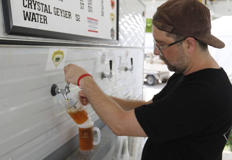 David Gibbons the head brewer at the Crystal Lake Brewing Company pours a Slalom King beer for a customer during the Lakeside Festival on Thursday, July 3, 2025, on the grounds of the historic Dole Mansion in Crystal Lake,