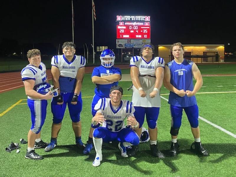 Riverside-Brookfield running back Ryan Novak (crouching) celebrates with teammates Joe Midona, Manny Garcia Rivera, David Hernandez, Jax Ramos and Phillip Vazanna after the Bulldogs' season-opening win over Morton on Friday, August 26, 2022.