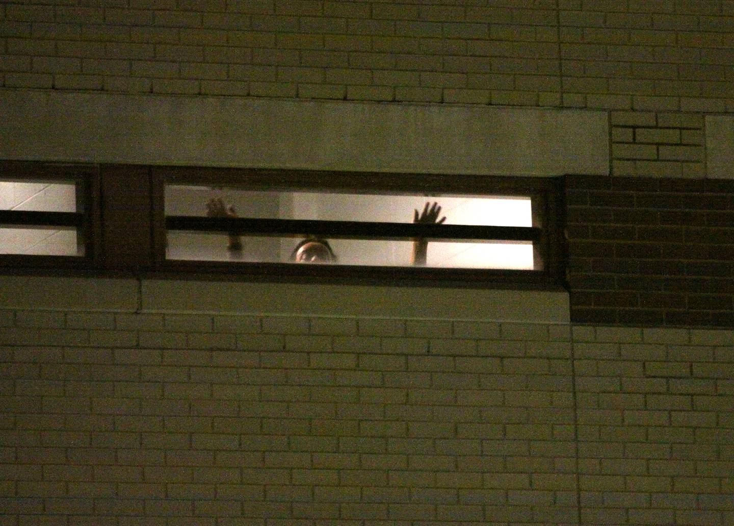 An inmate waves as activists held a candlelight march to the front of the McHenry County Correctional Facility the evening of Wednesday, Dec. 29, 2021.