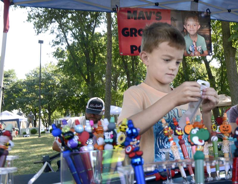 Maverick Jackson bags up another order for one of his “Groovy Pens” Saturday at Washington Park in Ottawa during the 4th annual Children’s Business Fair sponsored by Prairie Fox Books.