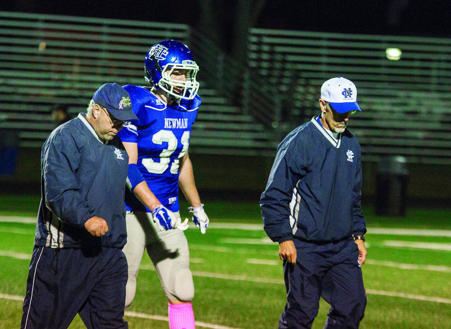 Newman's Nolan McGinn (center is walked off the field by Newman medical staff members Andy Accardi (left) and Joseph Welty (right) during the Comets' game against the Erie-Prophetstown Panthers.