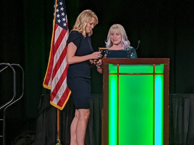 John Shields Elementary School kindergarten teacher Jillian Yaggie, left, accepts the Kane County Educator of the Year award from Regional Superintendent Patricia Dal Santo, right, of the Kane County Regional Office of Education.