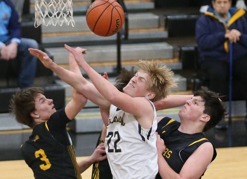 Marquette's Henry McGrath (center) along with Putnam County's Bryce Smith, Jaden Stoddard and Gavin Cimei reach up for a rebound during the Tri-County Conference Tournament on Tuesday, Jan. 23, 2024 at Putnam County High School.