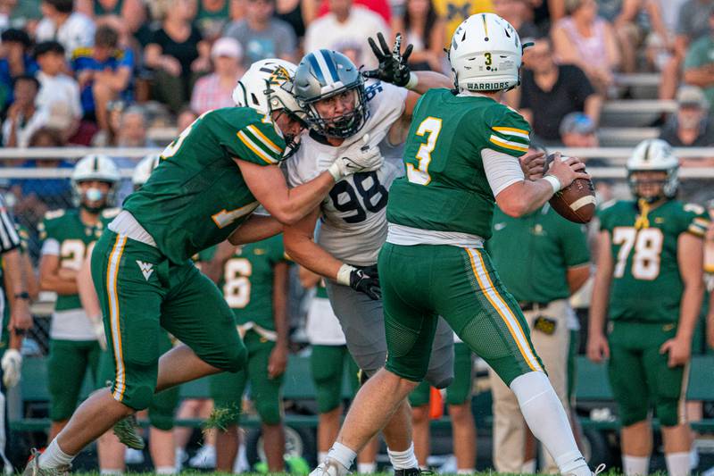Oswego East's Zach Morrisroe (98) applies pressure against Waubonsie Valley's Luke Elsea (3) during a football game at Waubonsie Valley High School in Aurora on Friday, Aug. 25, 2023.