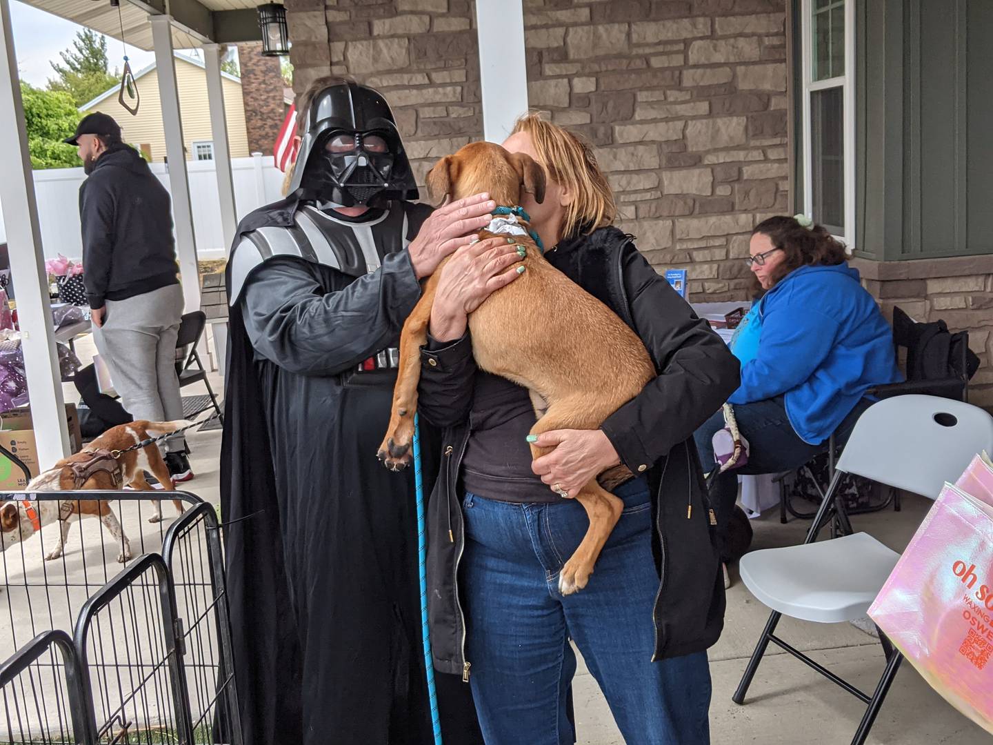 Dressed as Darth Vader, The Pets’ Home owner John Gay greets a dog at the Star Wars-themed adoption event the Oswego dog day care and boarding facility hosted on May 4.