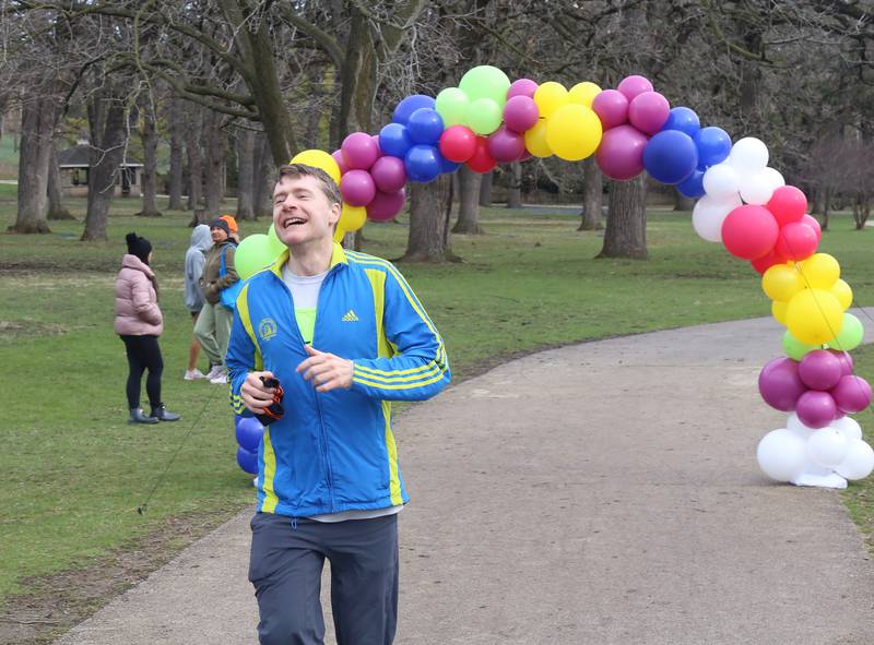 An enthusiastic Steve Breese from Palatine crosses the finish line at the Color Outside the Line 5K that was held in Geneva on April 5, 2025.