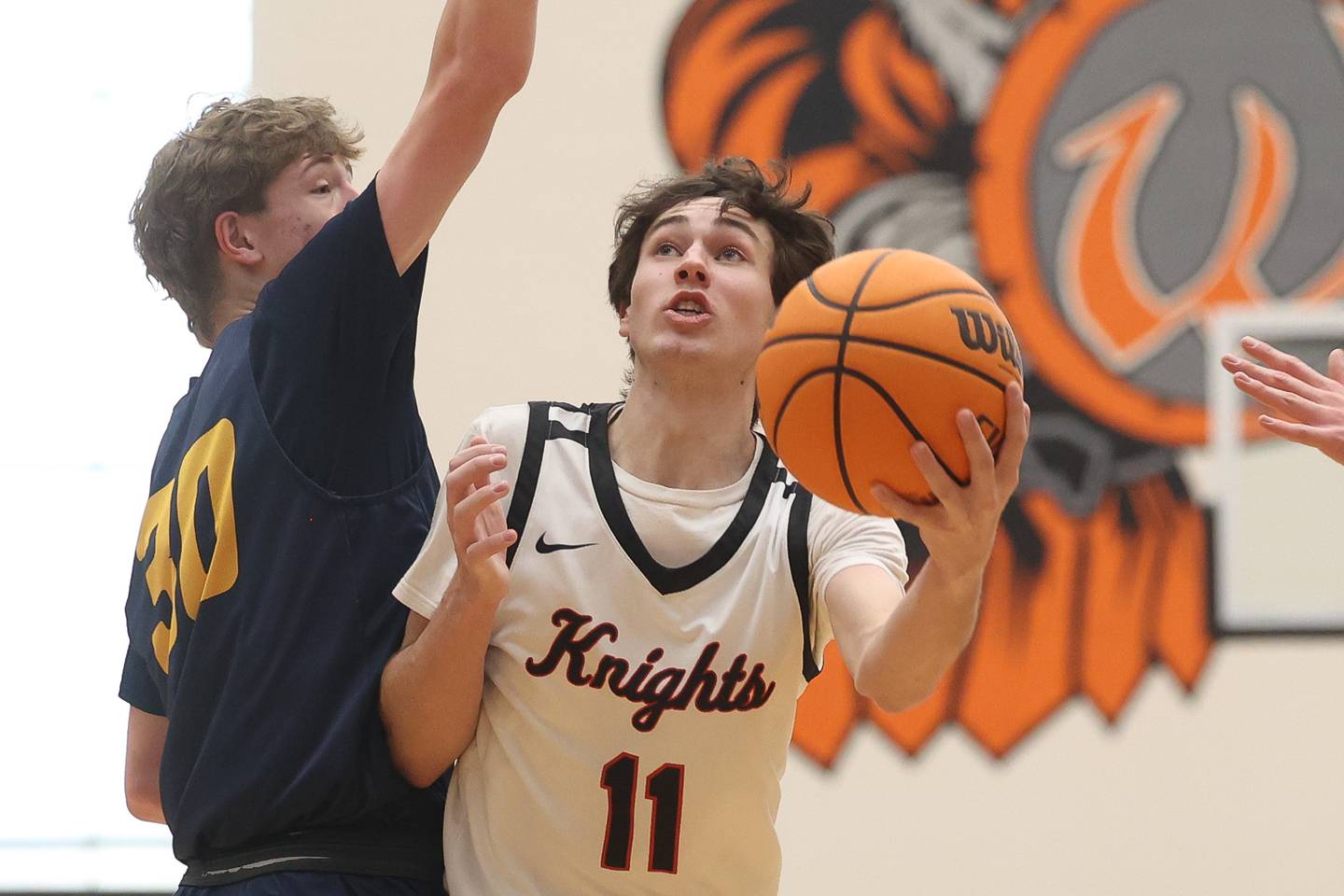 Lincoln-Way West’s Nick Brzezniak lays a shot up around  Neuqua Valley’s Mason Martin on Saturday, Feb. 1, 2025.