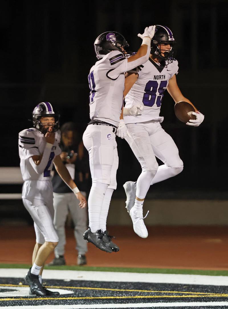 Downers Grove North's Charlei Cruse (11) congratulates Will Vala (85) after a touchdown during the varsity football game between Downers Grove North and York on Friday, Oct. 4, 2024 in Elmhurst.