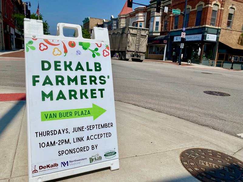 A sign advertising the DeKalb farmers market sits along Lincoln Highway and Second Street in downtown DeKalb on Thursday, June 5, 2025. The market opened its 30th year Thursday.
