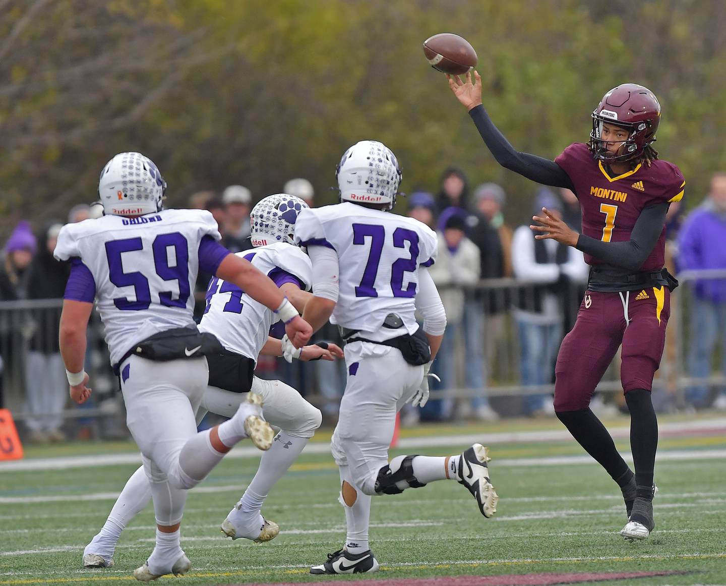Montini quarterback Israel Abrams passes over three Wilmington defenders during a Class 3A semifinal game on November 23, 2024 at Montini Catholic High School in Lombard.