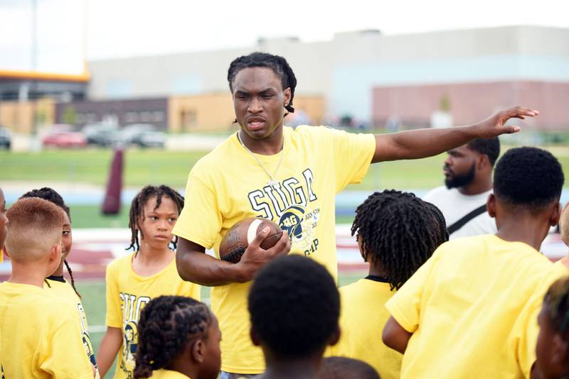 Jyaire “Suga” Hill, a 2023 Kankakee High School graduate and current defensive back for the University of Michigan, speaks to campers at his inaugural Suga Summer Camp at Kankakee High School last summer.