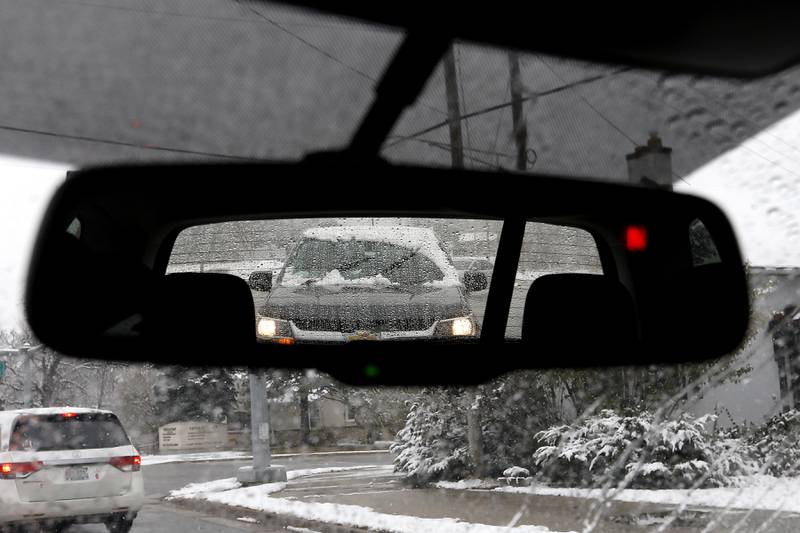 Snow covers a vehicle as waits for a traffic light to change at the intersection of Walkup Road and East Terra Cotta Avenue in on Tuesday, Nov. 15, 2022. The McHenry County area received its first measurable snowfall of the season on Tuesday.