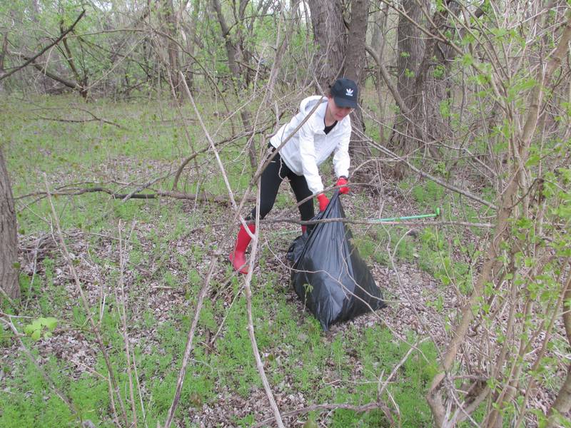 Kayleigh Parham, of La Salle, picks up trash near Lock 14 in La Salle during Perfectly Flawed Foundation's seventh annual Earth Day Cleanup on Saturday, April 22, 2023.