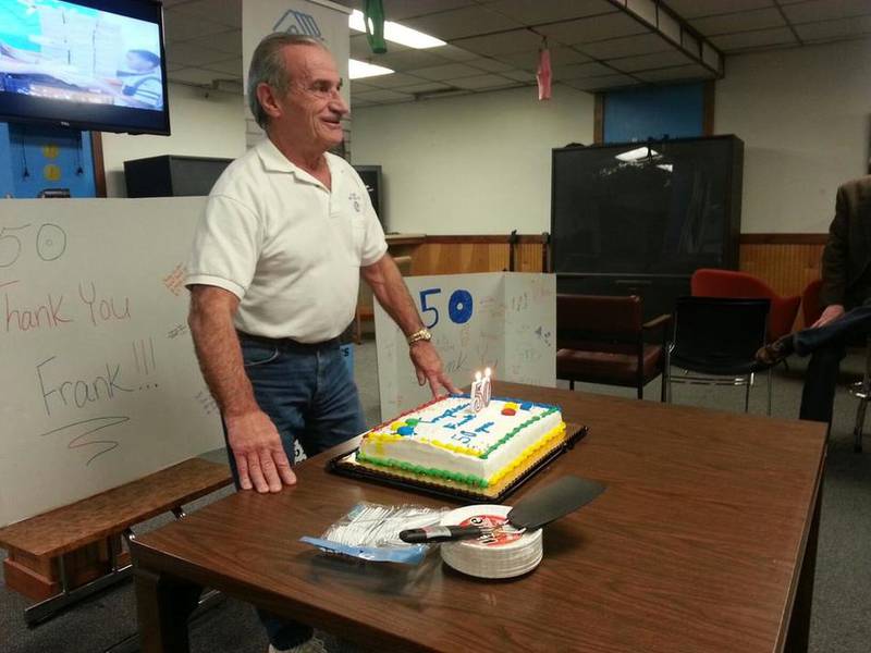Frank Bati, of the George Werden Buck Boys & Girls Club, prepares to blow out the candles of his cake Monday as he is celebrated for 50 years of service to the Joliet organization.
