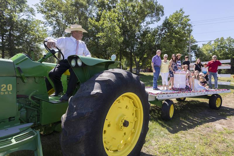 Mark Smith carries mom’s cremains and family up to the gravesite at Oakwood Cemetery Friday, July 7, 2023. Ruth Ann Pullen requested she be shuttled to her final resting place via a hayrack.