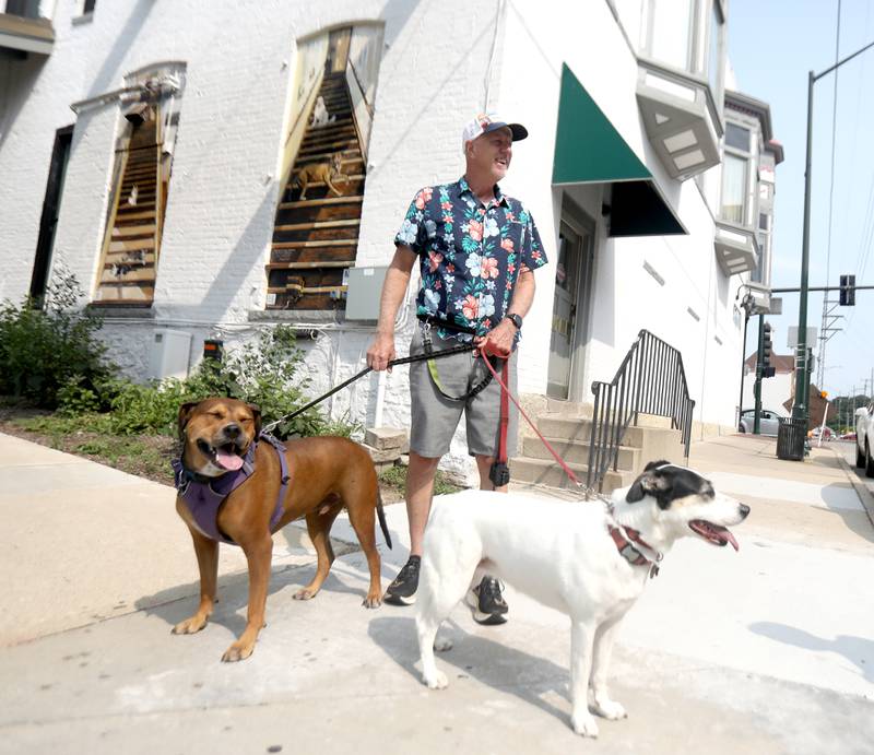 Artist Chris Cudworth used his two rescue dogs, Crash (right) and Lucy (left), as models for a mural he painted on the backside of the Fox.Build Makerspace building in downtown St. Charles.