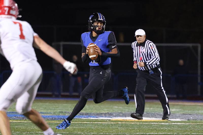 Lincoln-Way East’s Jonas Williams rolls out to pass against Naperville Central on Friday, Oct. 25, 2024 in Frankfort.