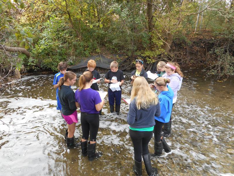 Students collect data about the water quality in their local stream under the guidance of a Friends of the Fox River educator.