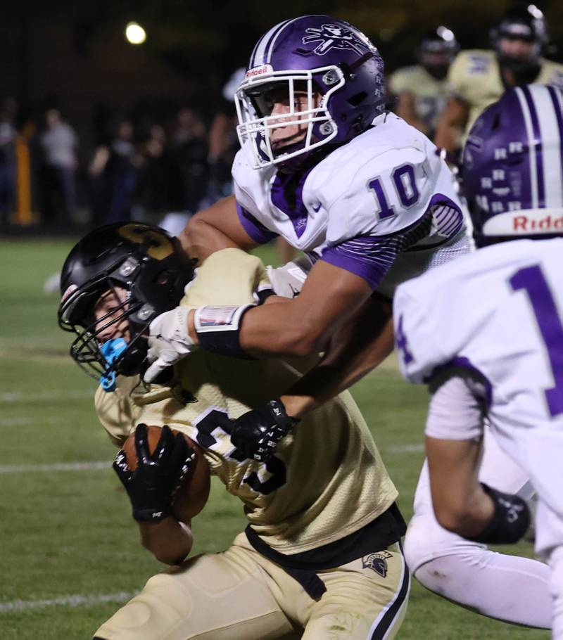 Sycamore's Benjamin Anderson takes a hit from Rochelle's Dylan Manning after making a catch during their game Friday, Sept. 19, 2025, at Sycamore High School.