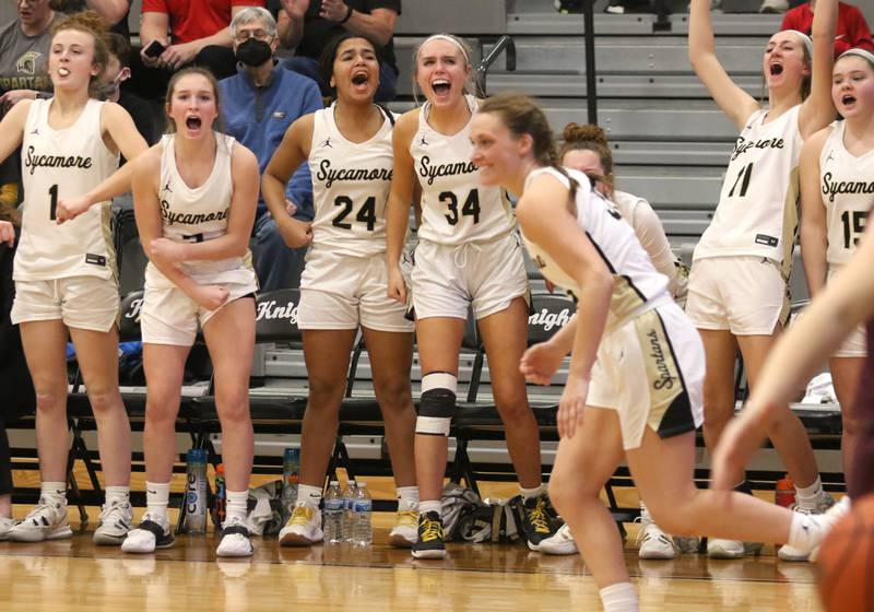 The Sycamore bench celebrates a three pointer made by Ella Shipley Thursday, Feb. 24, 2022, during the Class 3A sectional final game against Montini at Kaneland High School in Maple Park.
