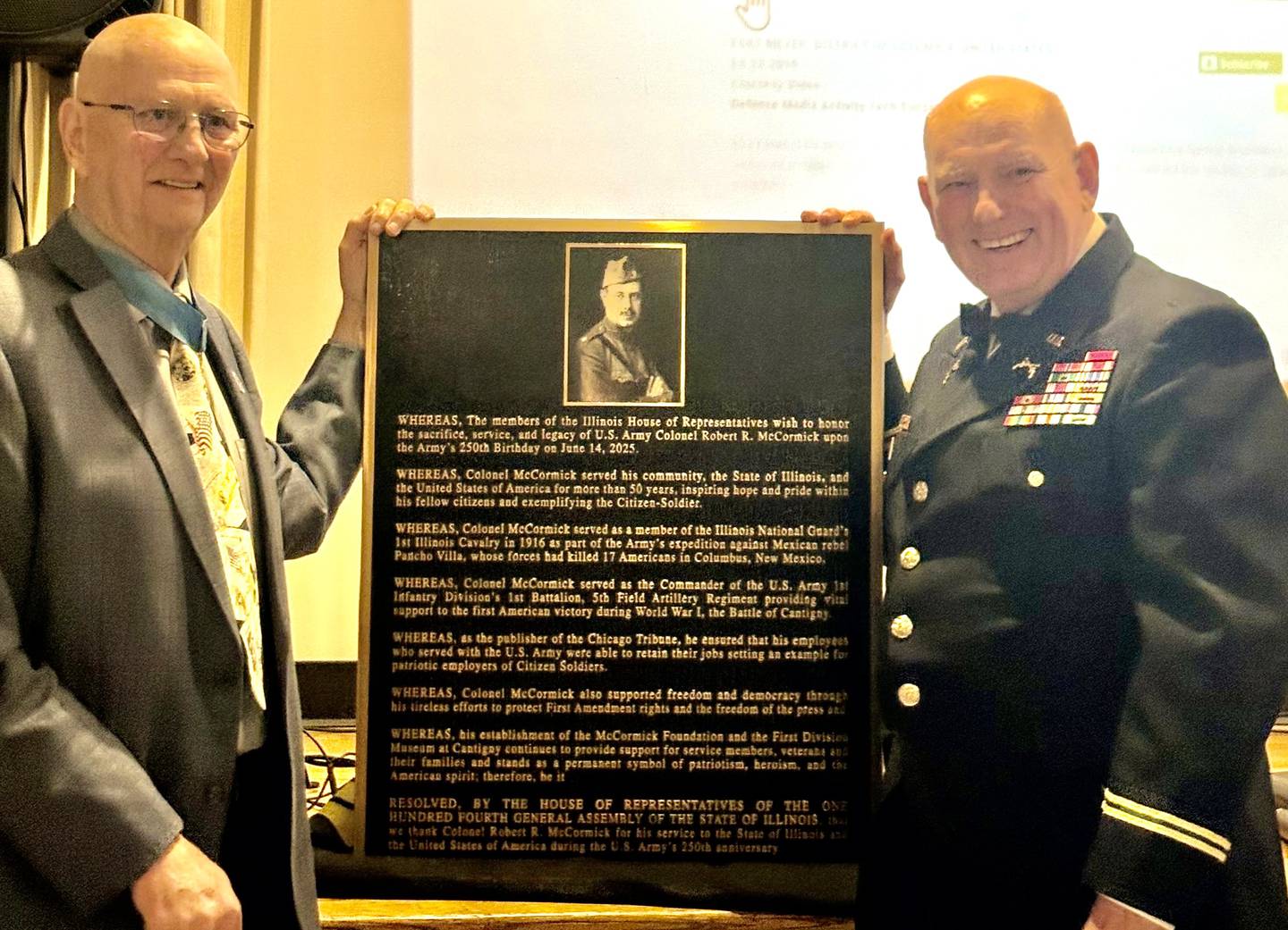Allen Lynch and Col. Mike Peck display the Colonel Robert McCormick plaque for permanent display at Cantigny.