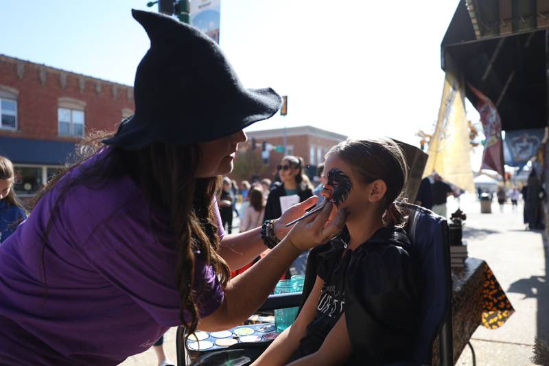 Halle Kubinski, 10 of Plainfield gets a raven painted on her face at the Magic in Morris event on Saturday.