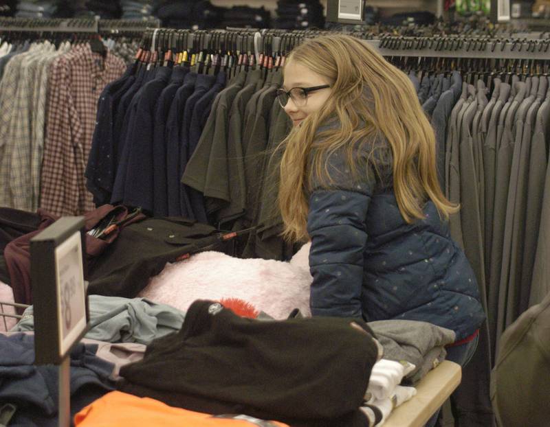 Abigai Unser looks over presents while shopping with Whiteside County sheriff's deputies Saturday, Dec. 13, 2025, at Sterling Walmart.