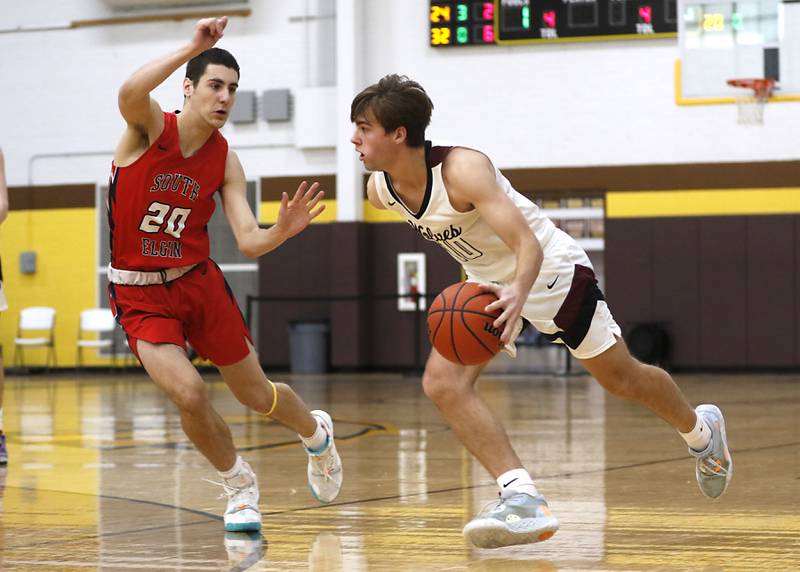 Prairie Ridge's Cade Collins drives on South Elgin’s Derek Clark during a Hinkle Holiday Classic basketball game Tuesday, Dec. 27, 2022, at Jacobs High School in Algonquin.