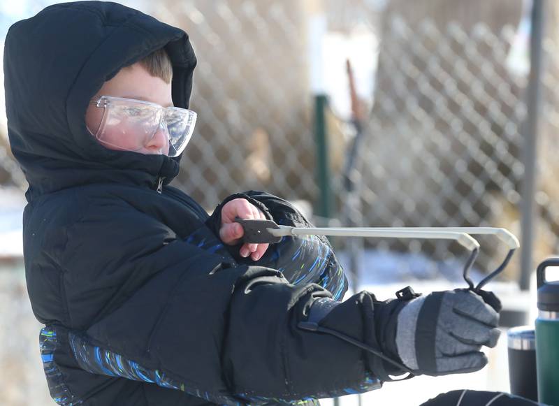 Brody Grubar of Utica, pulls back on a slingshot in the archery range during the Lowaneu Cub Scout Yukon on Saturday, Jan. 31, 2026 at Hall Township Echo Bluff Park in Spring Valley.