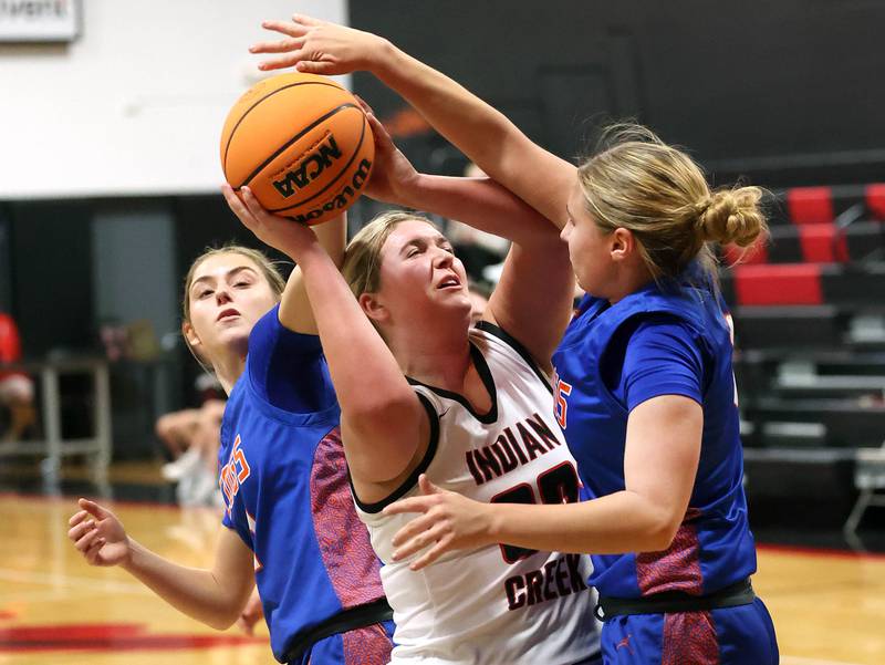 Indian Creek's Madison Boehne tries to get a shot up between Genoa-Kingston's Presley Meyer (left) and Genoa-Kingston's Ayva Hernandez Monday, Dec. 8, 2025, during their game at Indian Creek High School in Shabbona.