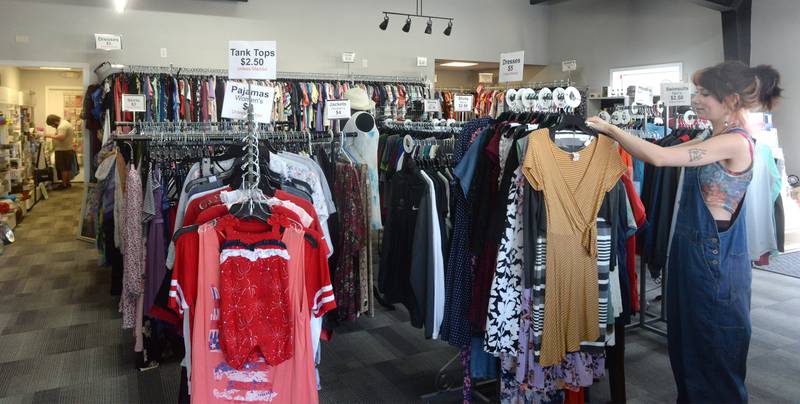 Grace Gabaldon arranges one of the racks of clothes for sale at Angel Treasures III in Dixon. The store opened May 1 and is one of three stores operated by Serenity Hospice and Home.